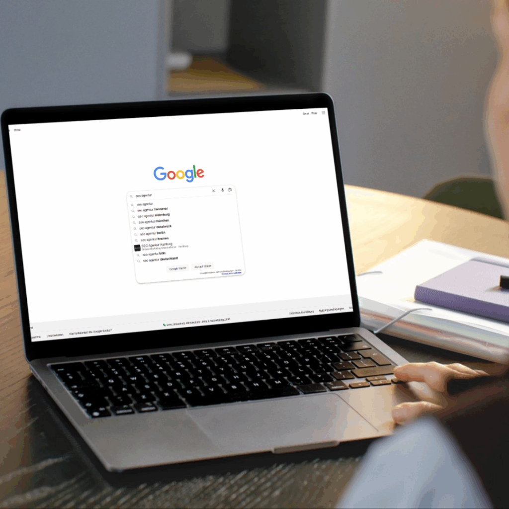 Person, die auf einem Laptop die Google-Suche nach "seo agentur" durchführt.
